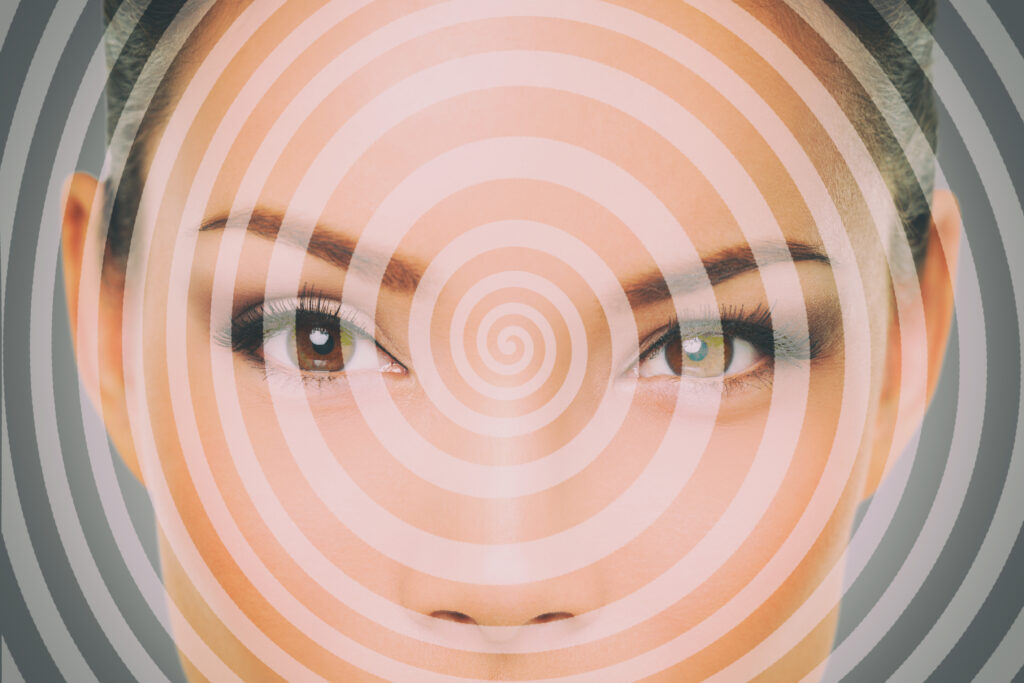 A photo of a female face with a hypnosis spiral superimposed upon it