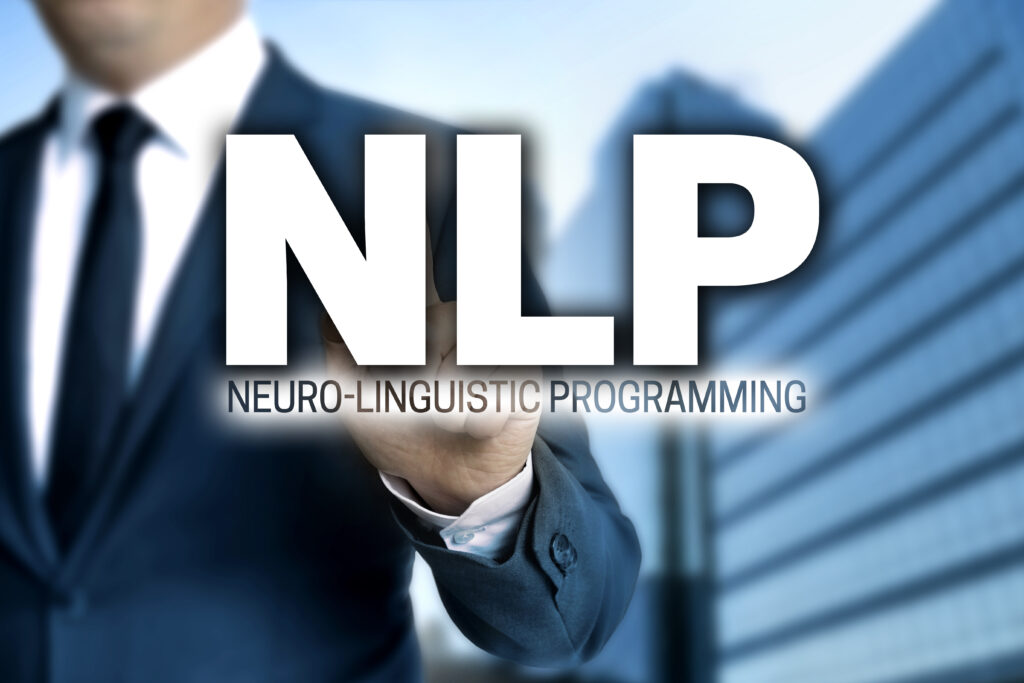 The legend ' NLP Neuro-Linguistic Programming' with a business man behind it and an office building behind him.